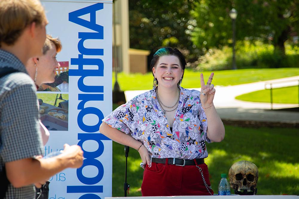 student smiling at an anthropology tabling